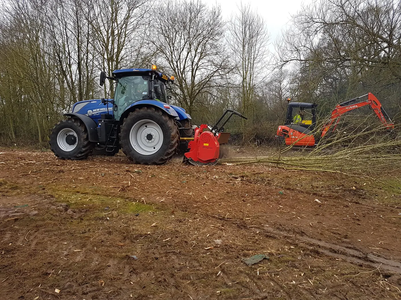 Tractor-mounted forestry equipment and excavator processing vegetation