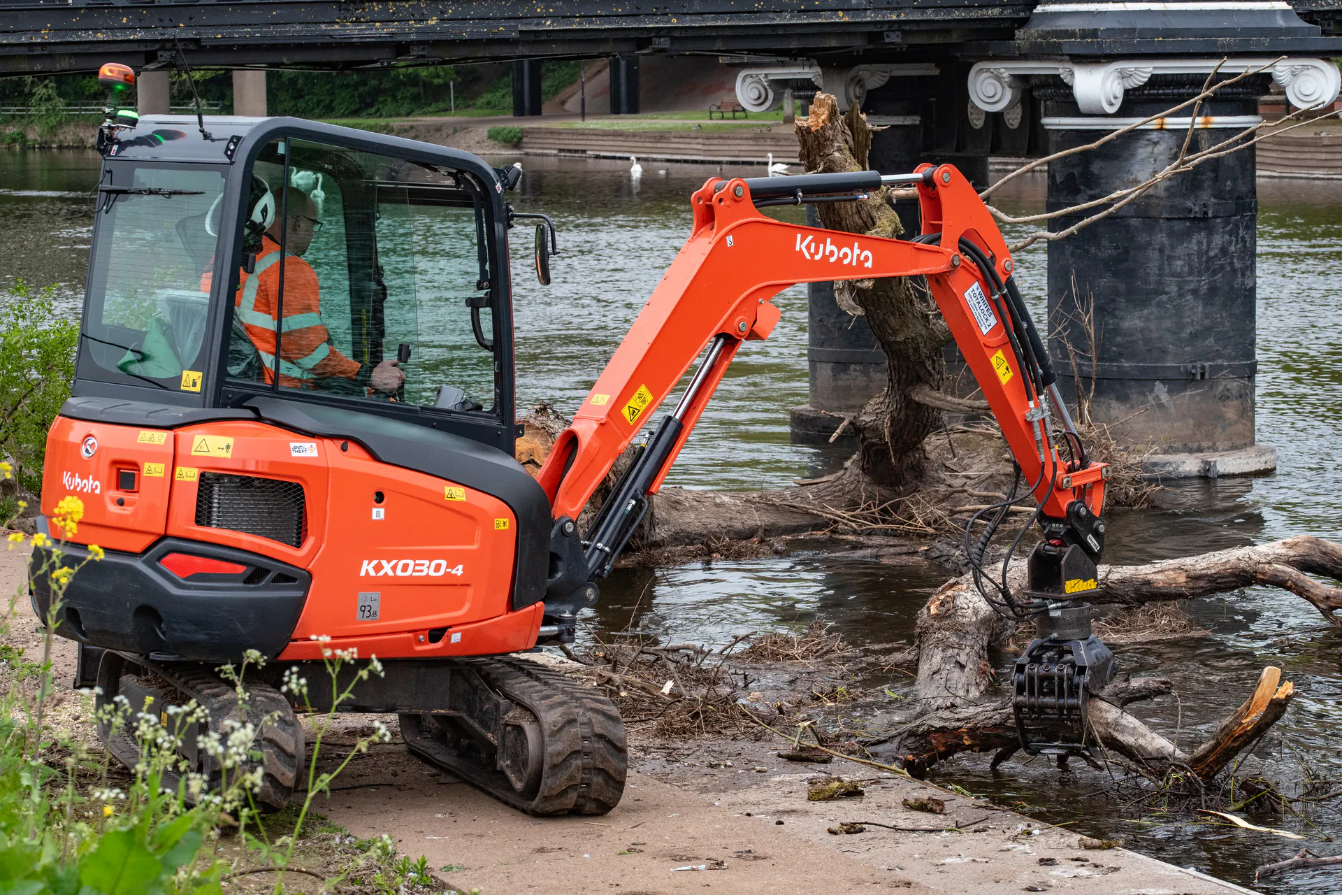 N&J Tree Services excavator removing fallen timber from a waterway beside a bridge
