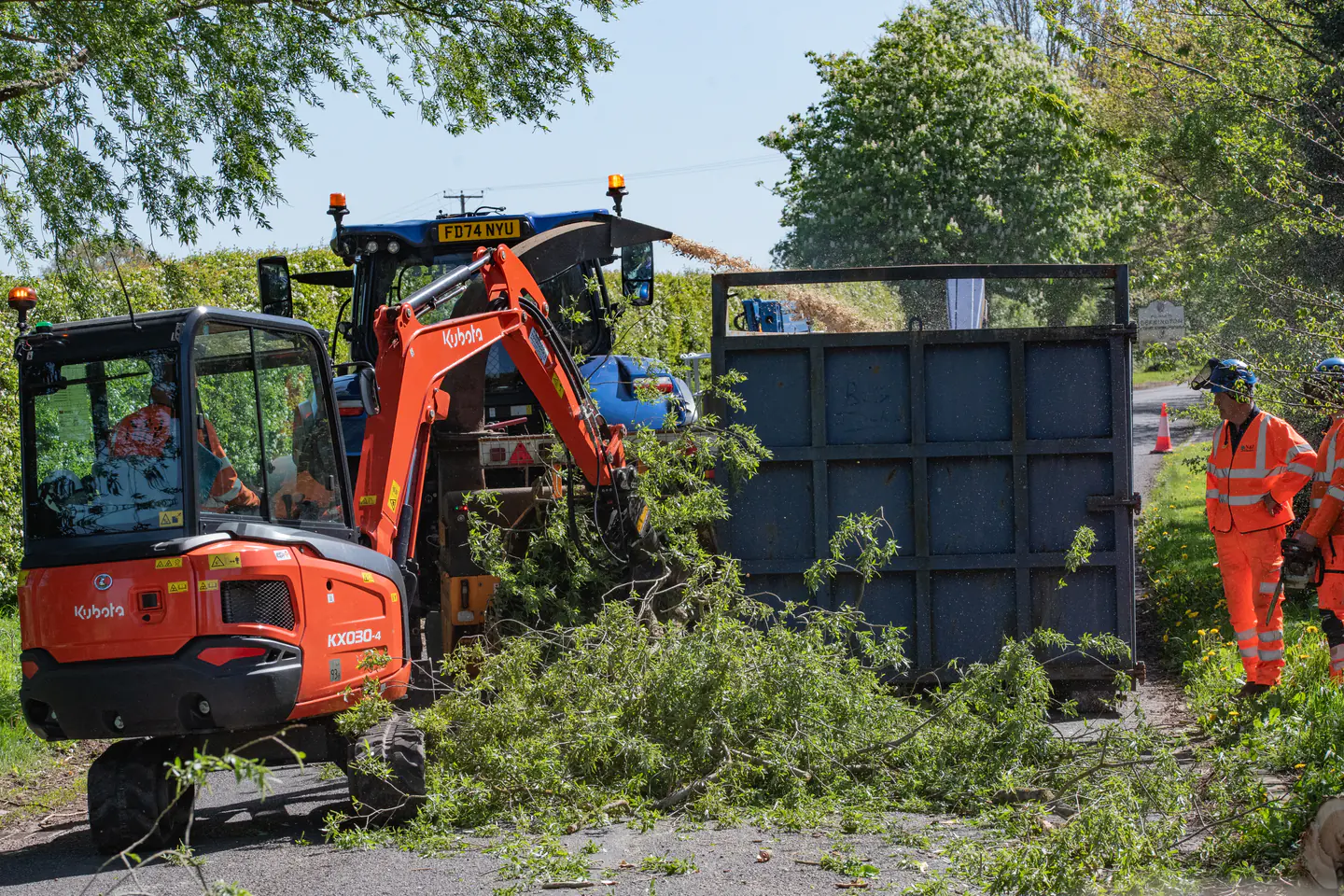 Excavator and tractor processing vegetation during a mechanised clearance operation