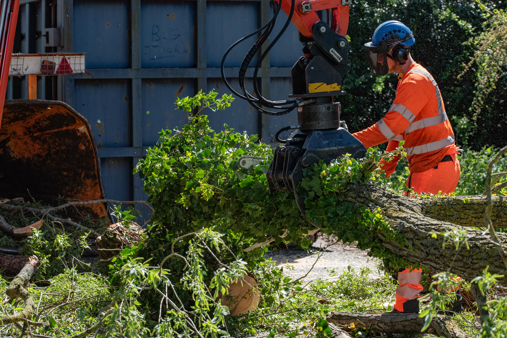 N&J Tree Services operative processing felled vegetation with specialist excavator equipment